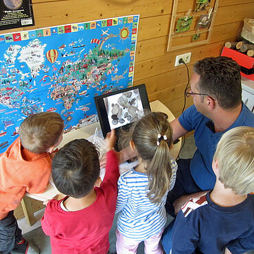 Kinder betrachten eine Weltkarte