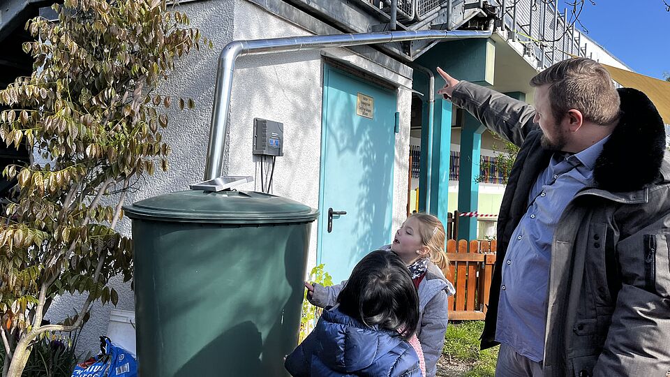 Die Kinder der Kita Goldfischchen in Berlin bewässern ihr Hochbeet im Kita-Garten mithilfe eines Gießroboters.