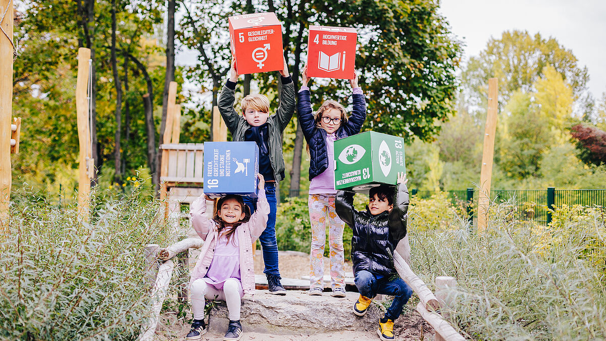 Kinder halten die Nachhaltigkeitsziele (SDG) in die Luft