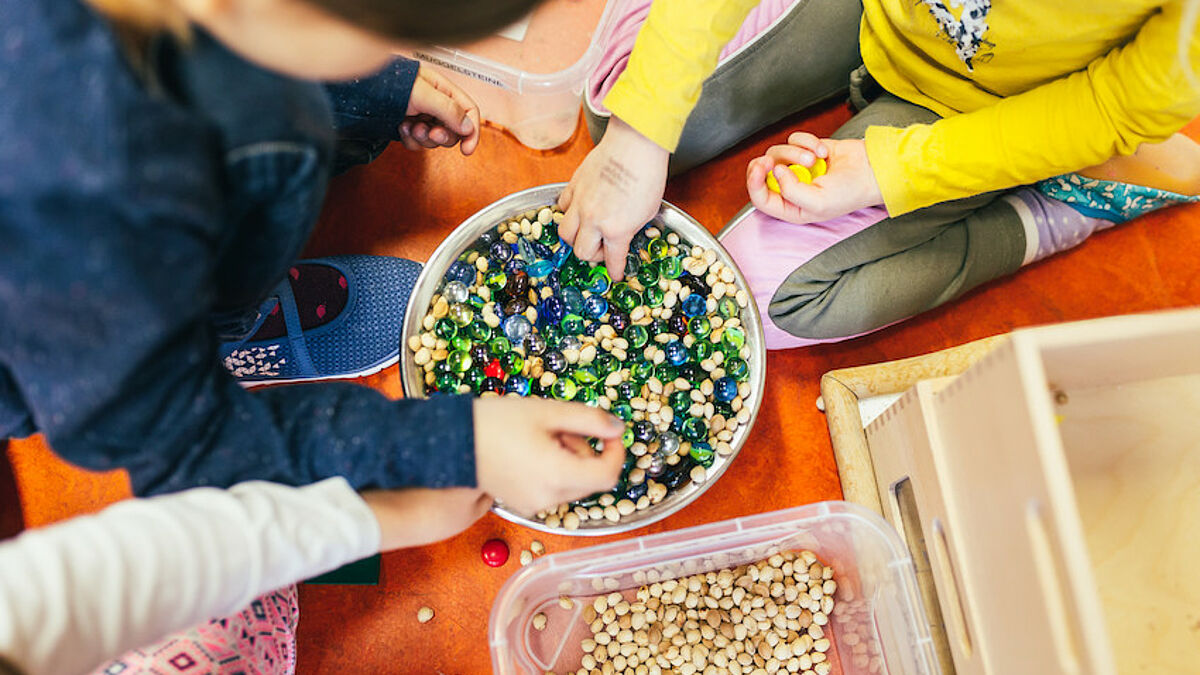 Kinder sortieren Glasmurmeln und Hülsenfrüchte