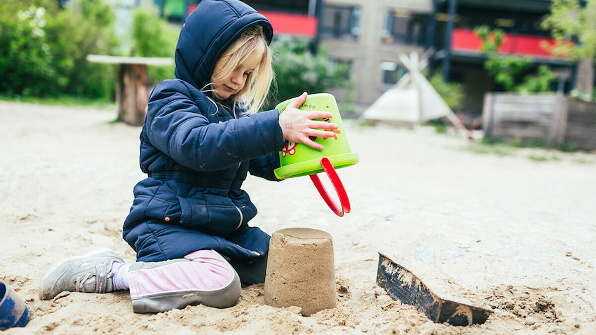 Kind baut Formen aus Sand